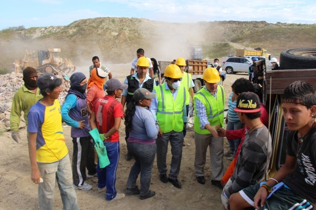 El alcalde de Manta y el ministro del Ambiente saludan con chamberos que recuperan hierro en el depósito de escombros en el Valle del Gavilán. Manta, Ecuador.