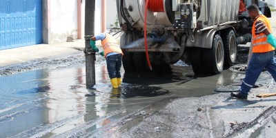 Operadores de una máquina de succión hidráulica limpian una alcantarilla en Altagracia de Manta. Manabí, Ecuador.
