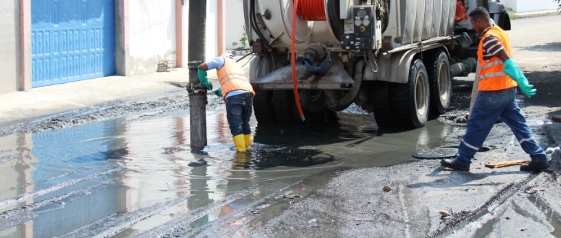 Operadores de una máquina de succión hidráulica limpian una alcantarilla en Altagracia de Manta. Manabí, Ecuador.