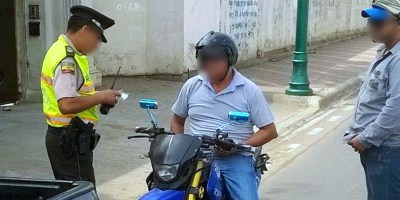 Un motociclista es detenido por la Policía para verificar que porta sus documentos en regla. Manabí, Ecuador.