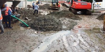 Obreros y maquinaria municipal de Manta reparan una calle después de la lluvia. Manabí, Ecuador.