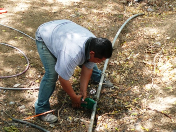 Un técnico de la EPAM inhabilita una toma clandestina de agua potable. Manabí, Ecuador.