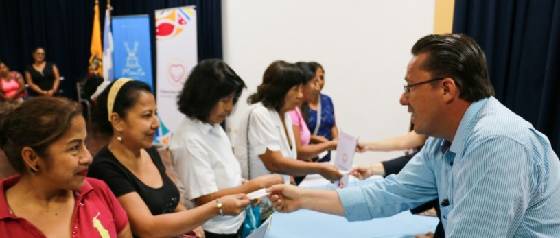 El doctor Jimmy Asanza, director del Área Médica del Patronato municipal de Manta, entrega tickets a mujeres cuyas serán examinadas en la Clínica Centeno. Manabí, Ecuador.