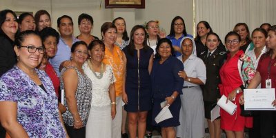 La Ministra de Justicia posa con un grupo de personas que trabajan para erradicar la violencia intrafamiliar en Manabí, Ecuador.