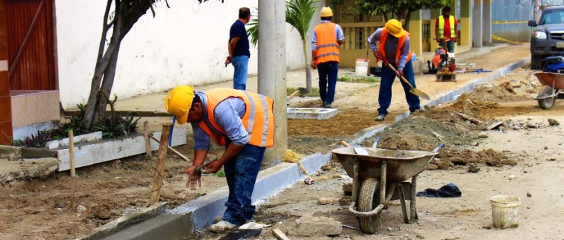 Obreros del Consorcio Tarqui reconstruyen un tramo de acera de una calle de Tarqui, Manta. Manabí, Ecuador.