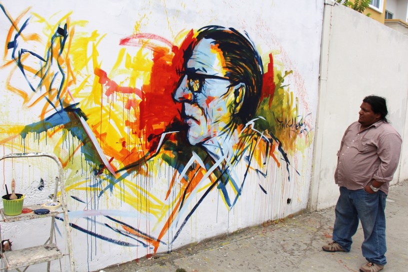 Efigie de Hugo Mayo en un mural en Manta. Lo observa su autor, Freddy Fiallos (Dadá).