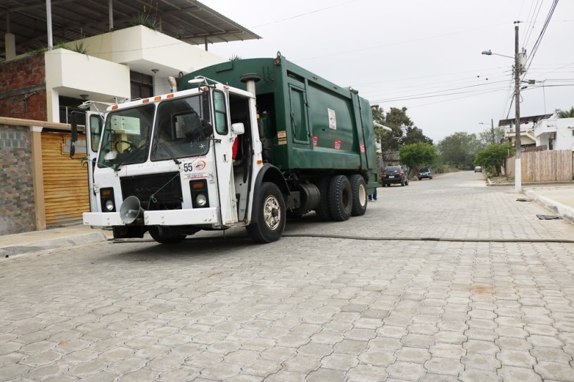 Un camión municipal recoge basura de los hogares que están a ambos lados de esta calle de Chone. Manabí, Ecuador.
