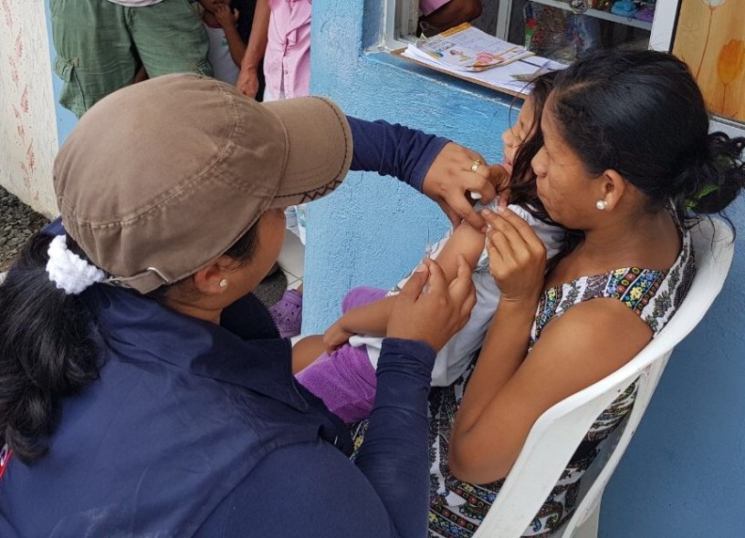 Brigadista de salud vacuna contra la gripe a una niña menor de edad. Manabí, Ecuador.