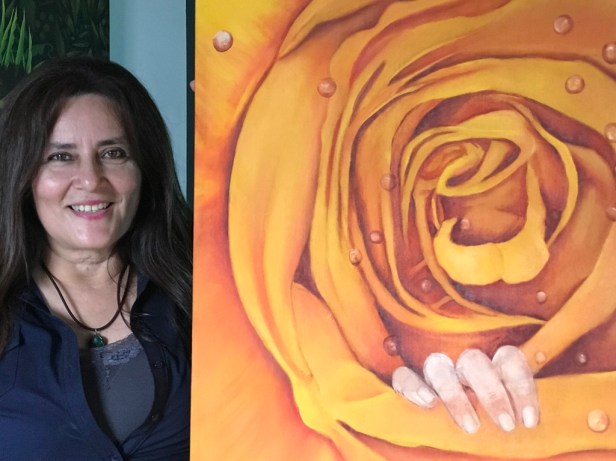 Johanna Meza Fuentes, junto a una de sus pinturas expuestas en Arte en Acción, Manta. Manabí, Ecuador.