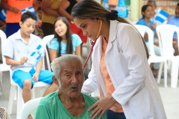 Una médica revisa los signos vitales de un paciente de la Tercera Edad en un barrio de Manta. Manabí, Ecuador.
