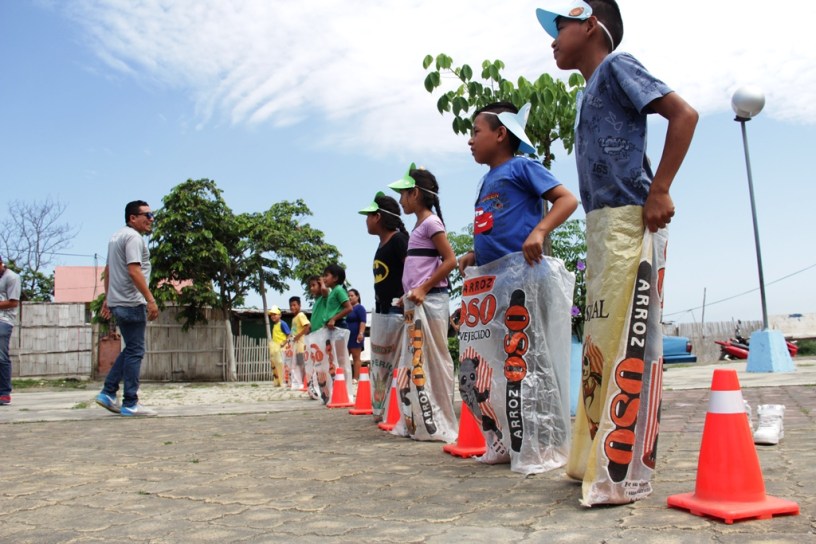 Niños participan en una carrera de ensacados organizada por el Patronato municipal de Manta. Manabí, Ecuador.
