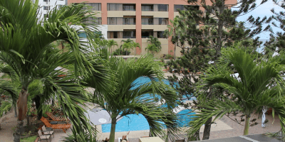 Vista de una piscina entre palmeras, en un hotel de Manta. Manabí, Ecuador.