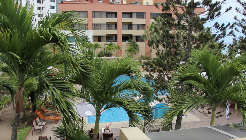 Vista de una piscina entre palmeras, en un hotel de Manta. Manabí, Ecuador.