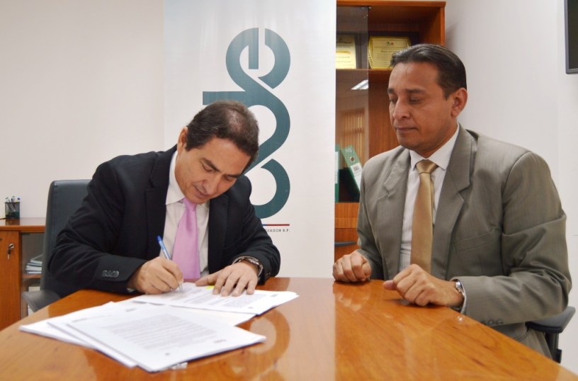 Ignacio Mendoza, gerente del BDE en Manabí, suscribe el convenio de crédito para construir el mercado de Charapotó. Observa Manuel Gilces, alcalde del Cantón Sucre. Manabí, Ecuador.