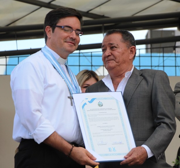 El vicealcalde de Manta, Eduardo Velásquez García, entrega la Condecoración Umiña del Concejo municipal al sacerdote André Drouet Salcedo. Manabí, Ecuador.