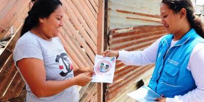 Mujer ecuatoriana recibe un bono de ayuda social. / FOTO: MIES