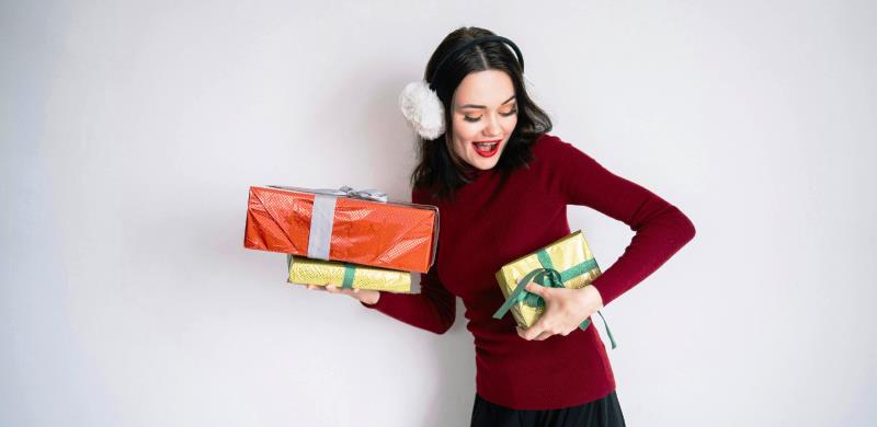 Mujer lleva paquetes con regalos navideños. / FUENTE: Kantar I. M.